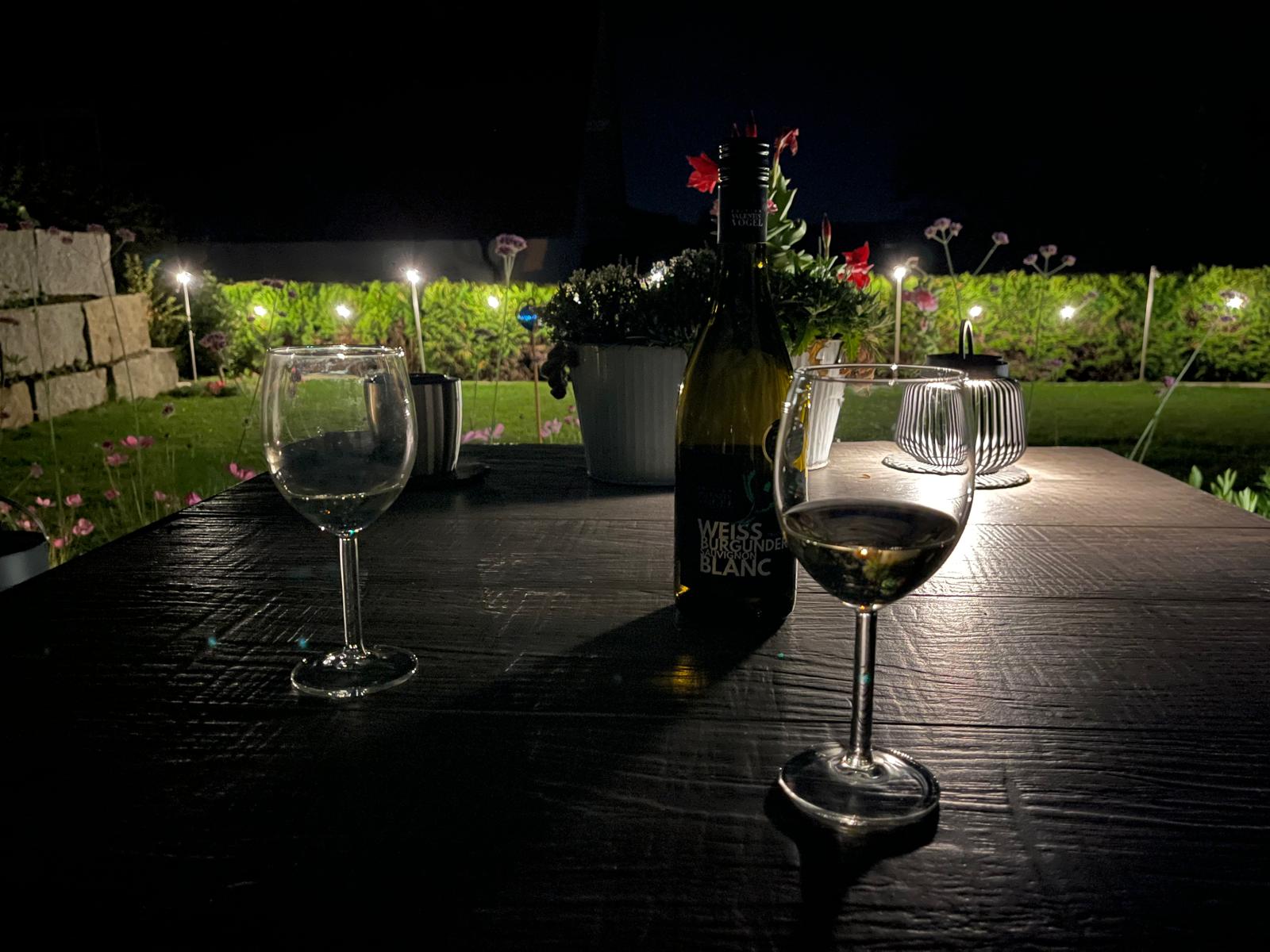 Weingläser auf der Terrasse bei Nacht